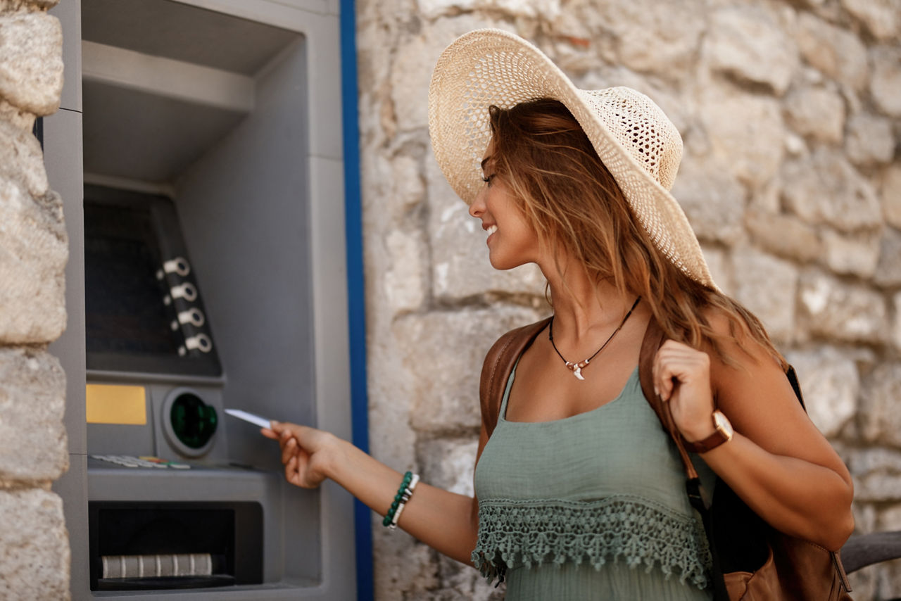 Frau führt die BankCard der Sparda-Bank Berlin in einen Geldautomaten ein