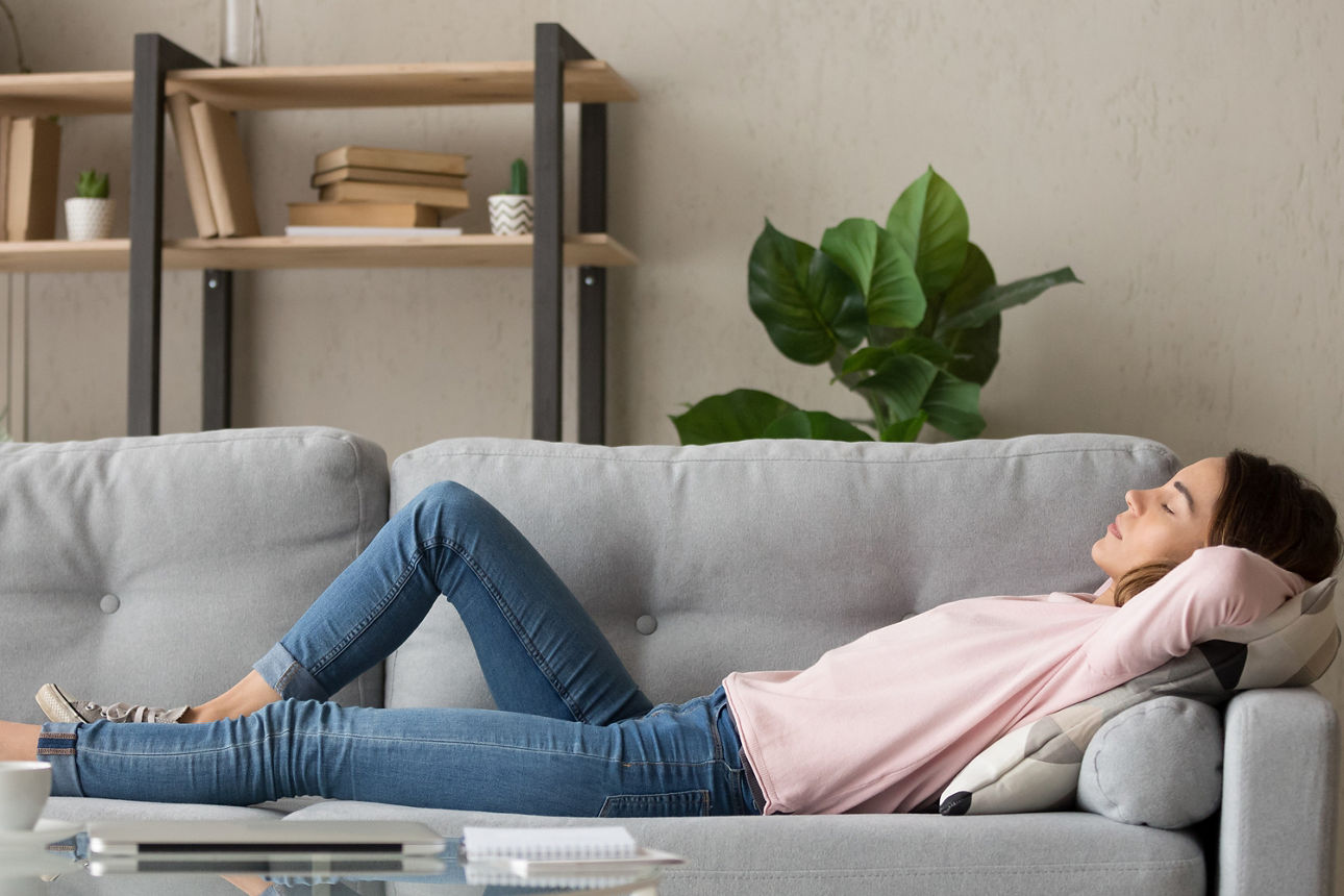 Frau liegt auf einer Couch