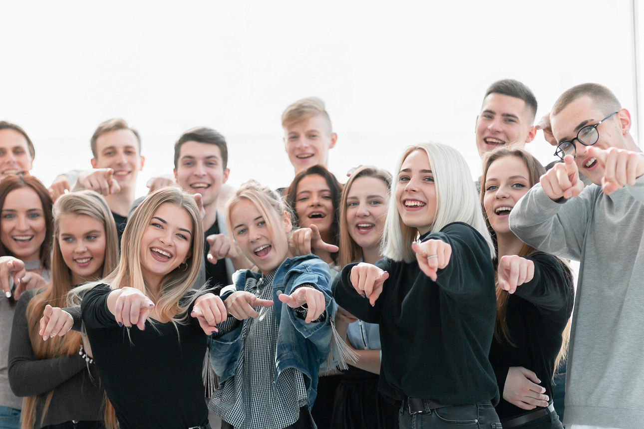 Gruppe Jugendlicher zeigt Richtung Bildschirmnutzer