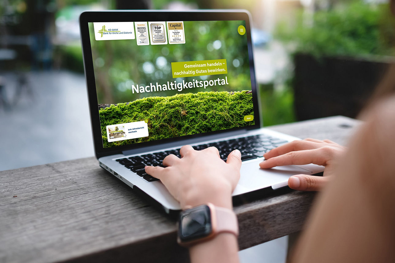 Ein Laptop steht auf einem Tisch und wird von einer Person benutzt