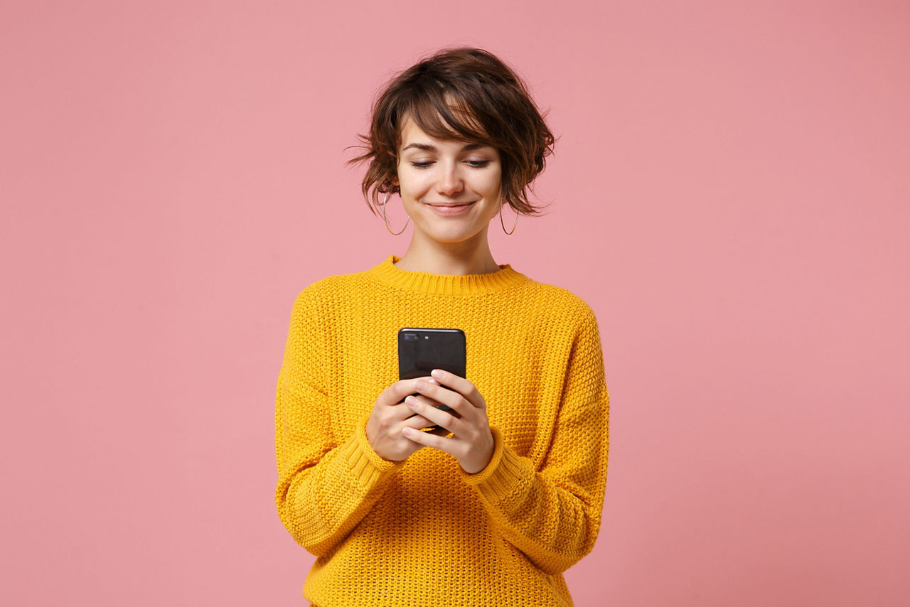 Eine Frau hält ein Smartphone und lächelt