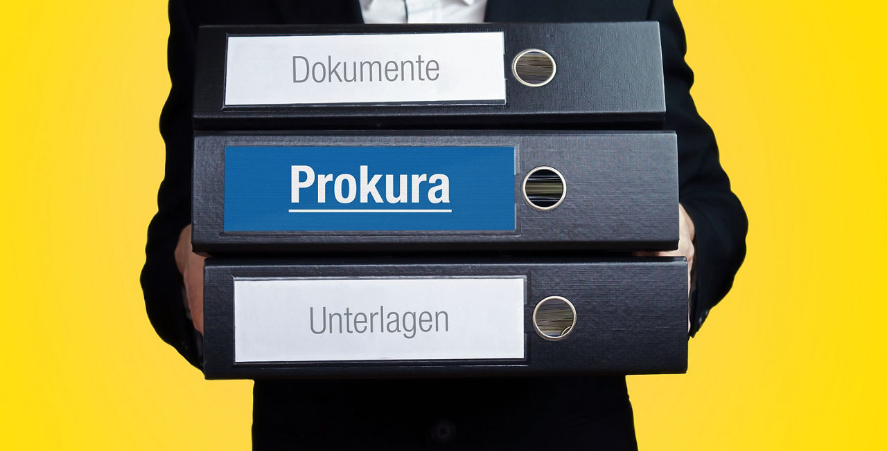 Anwalt im Anzug trägt einen Stapel Ordner. 3 Aktenordner. Blaue Beschriftung mit Text. Hintergrund gelb. Recht, Gesetz, Rechtsprechung