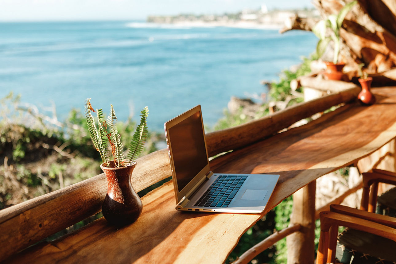Bar am Meer. Auf dem Tisch steht ein Laptop