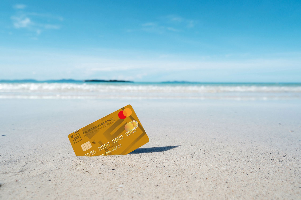 Mastercard Gold steckt am Sandstrand im Sand 