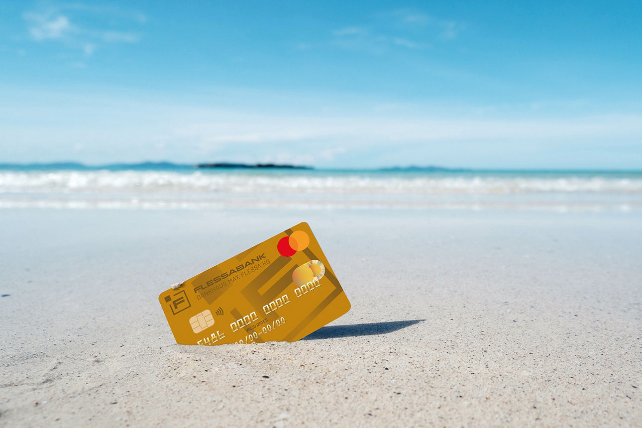 Mastercard Gold steckt am Sandstrand im Sand 
