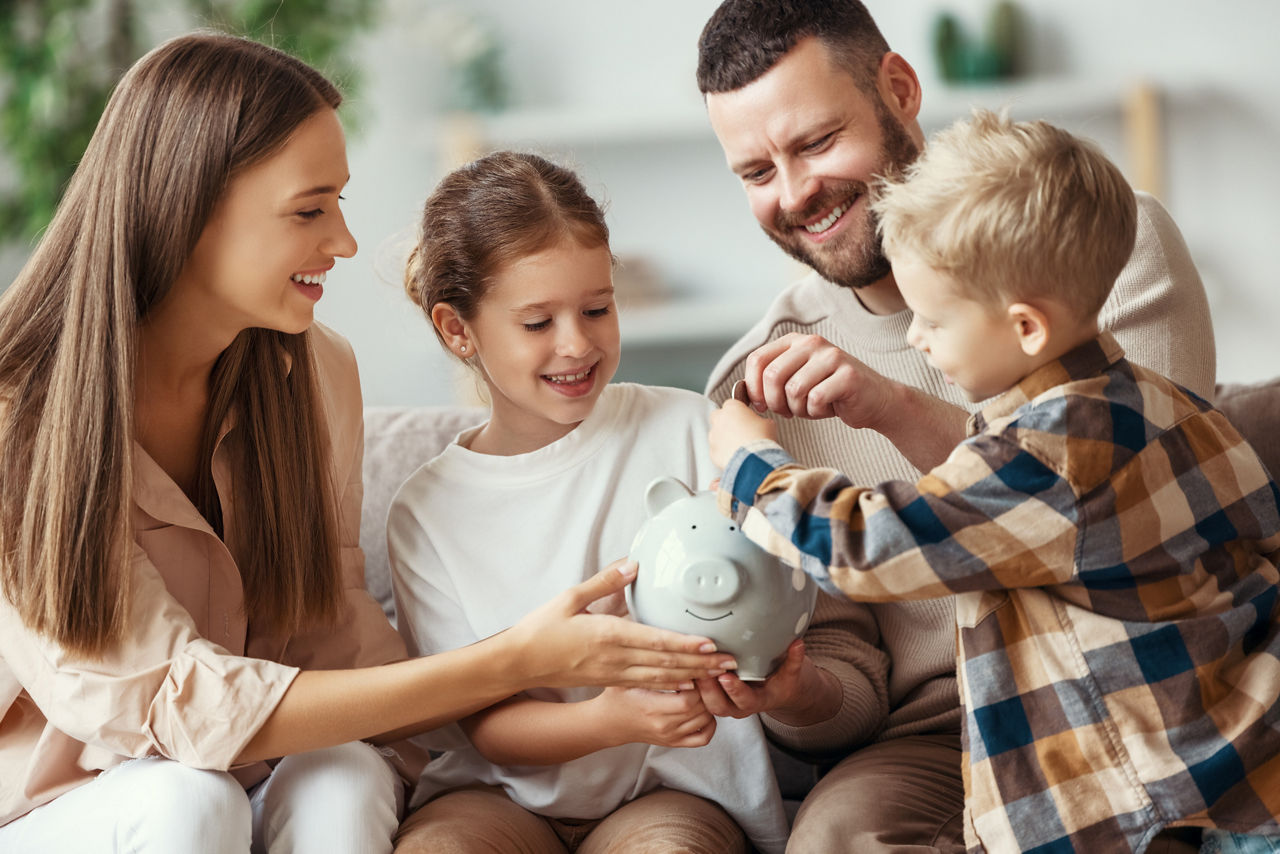 Familie wirft Münze in Sparschwein