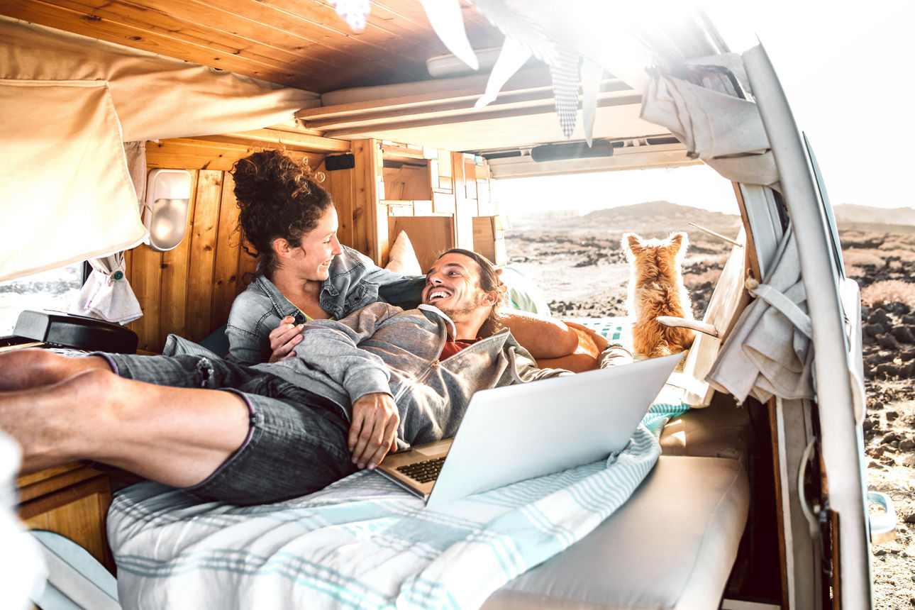 Kfz-Versicherung Paar liegt am morgen entspannt in ihrem Campingwagen