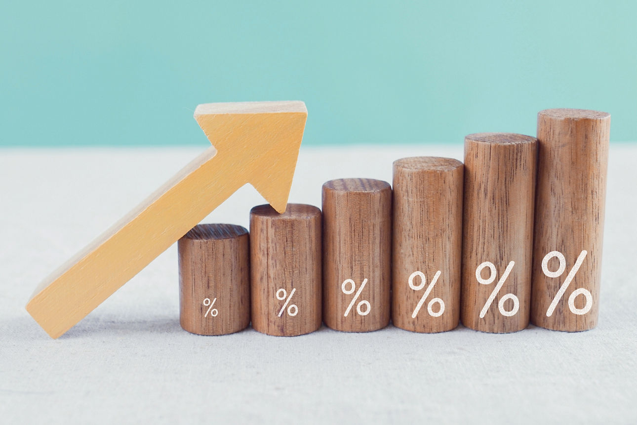 Mehrere größer werdende Bauklötze mit Prozentzeichen und ein Pfeil nach oben