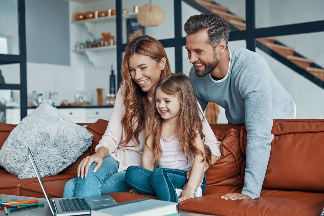 Junge Familie sitzt vor Laptop