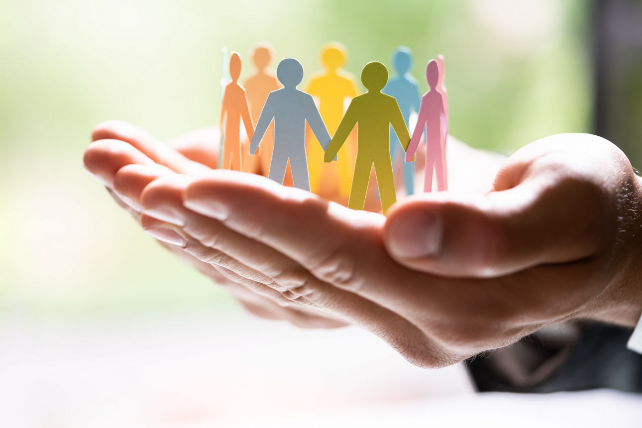 Eine gebastelte Menschenkette hält sich an den Händen.