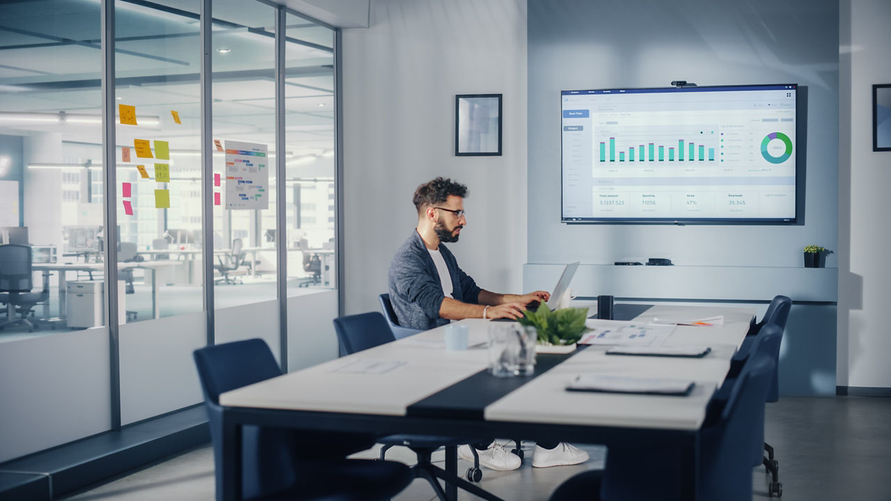 Eine Person arbeitet am Laptop in einem Besprechungsraum