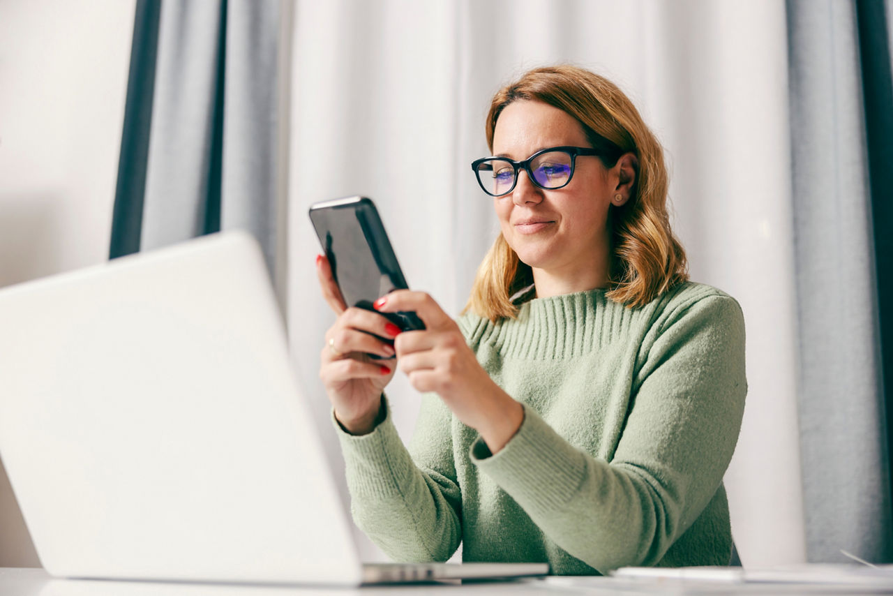 Zwei Hände halten ein Smartphone mit geöffneter Volksbanken-Raiffeisenbanken-Seite