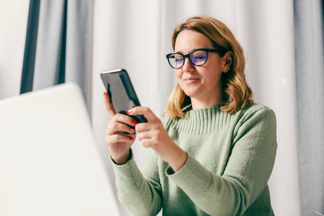 Zwei Hände halten ein Smartphone mit geöffneter Volksbanken-Raiffeisenbanken-Seite