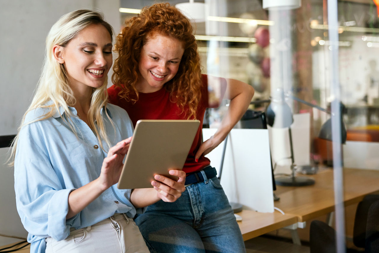 Darstellung von zwei jungen Frauen, die auf ein iPad schauen