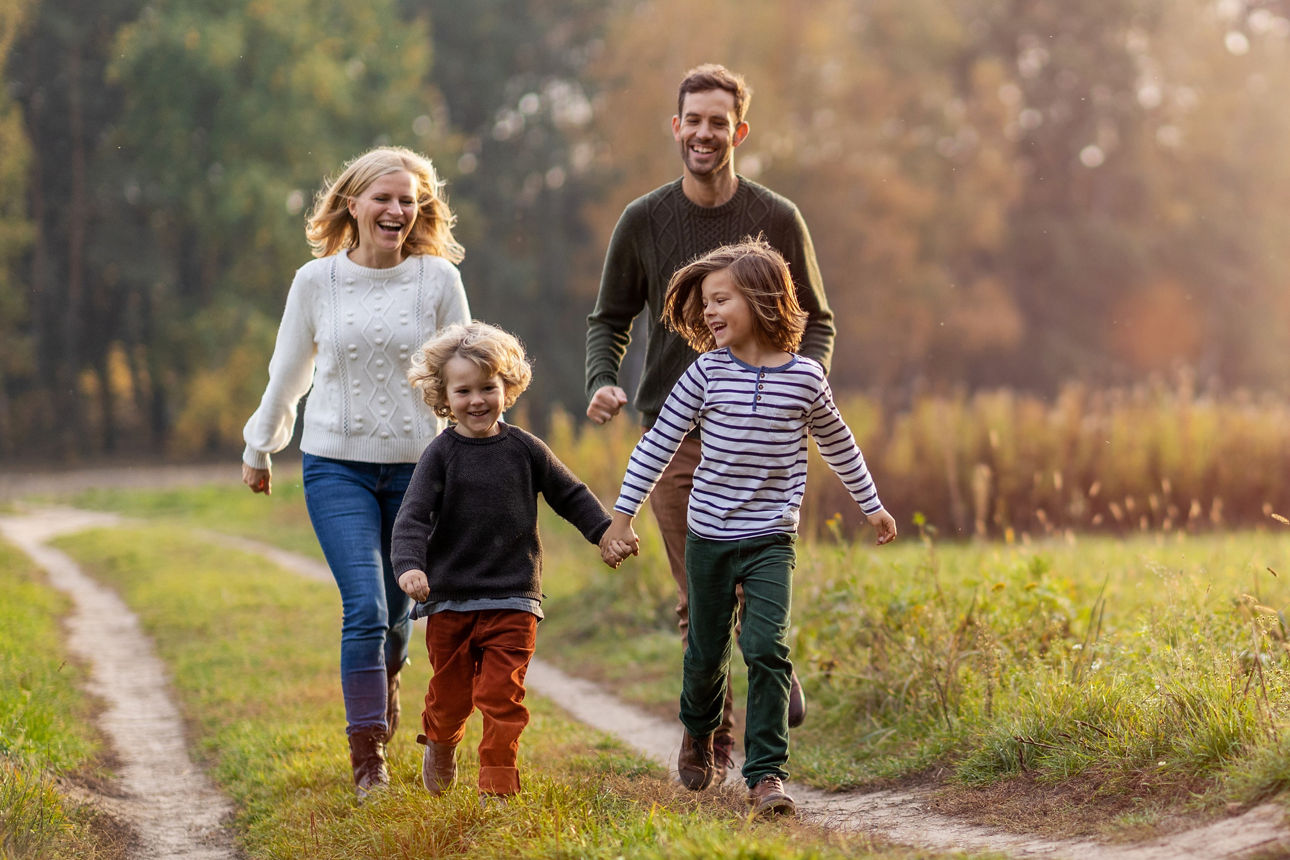 Familie läuft einen Feldweg entlang