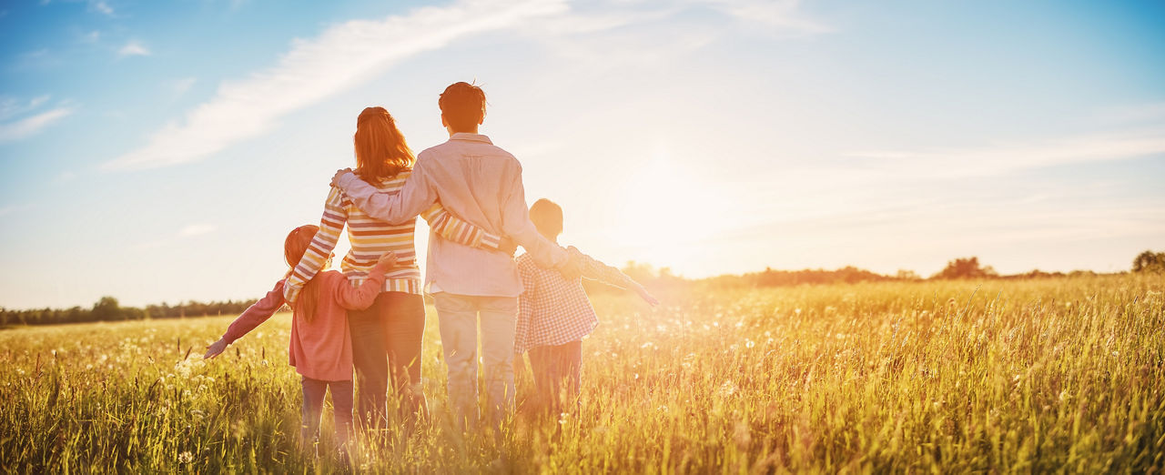 Happy family in the nature together on the evening sunset. Panoramic view. Concept of the vacation and relationship.