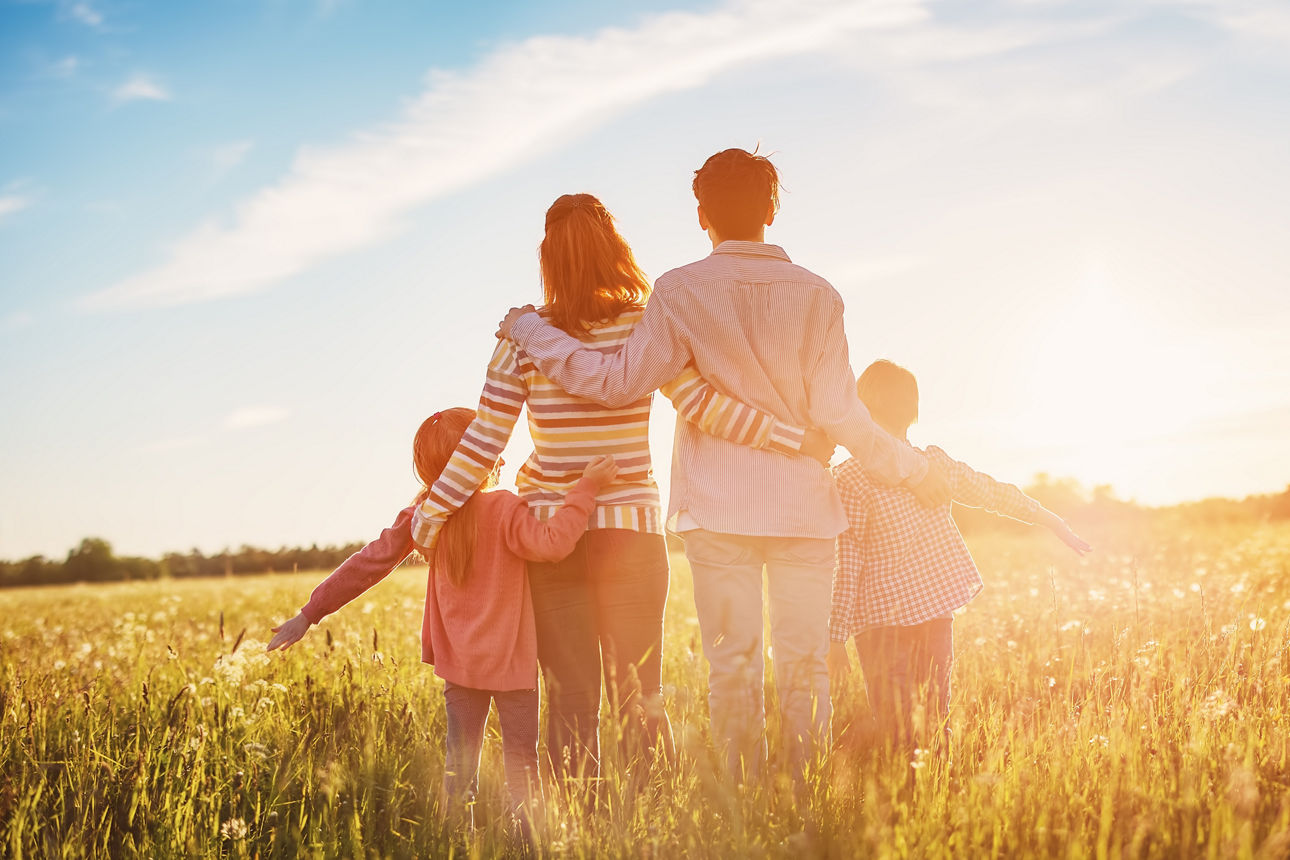 Happy family in the nature together on the evening sunset. Panoramic view. Concept of the vacation and relationship.