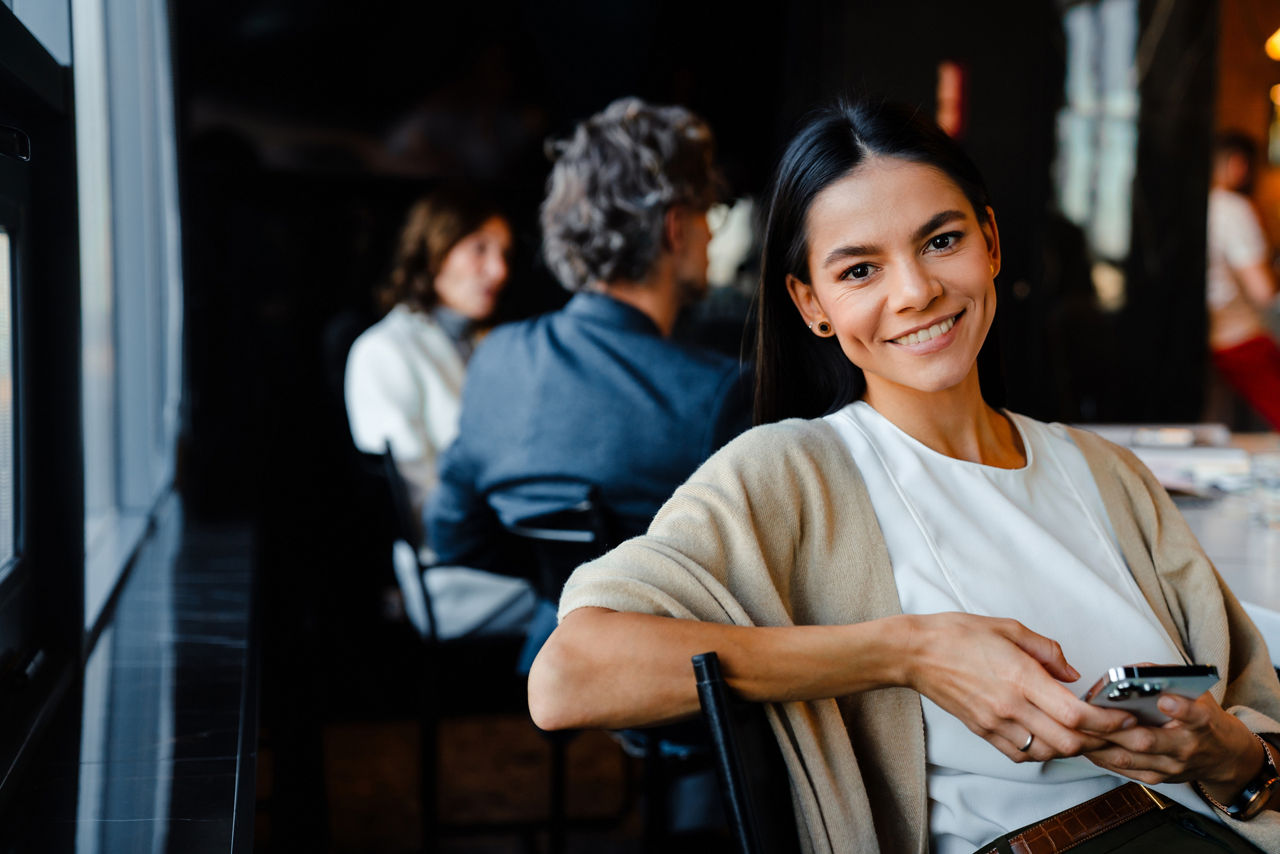 Eine Frau im Restaurant mit Smartphone in der Hand