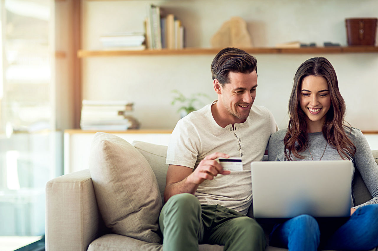 Pärchen auf der Couch freut sich über das Tagesgeld