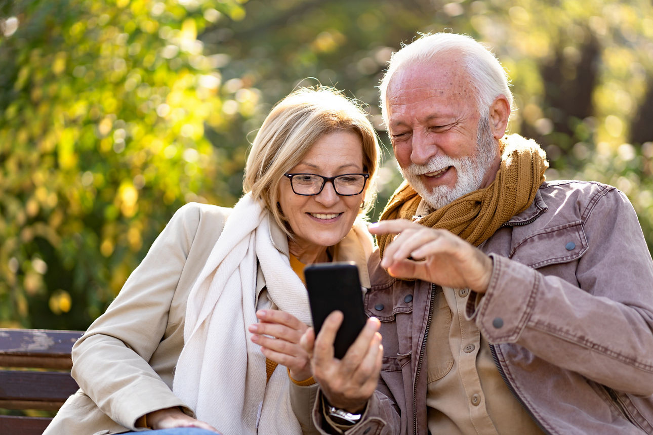 Ein Paar schaut freudig auf ein Smartphone