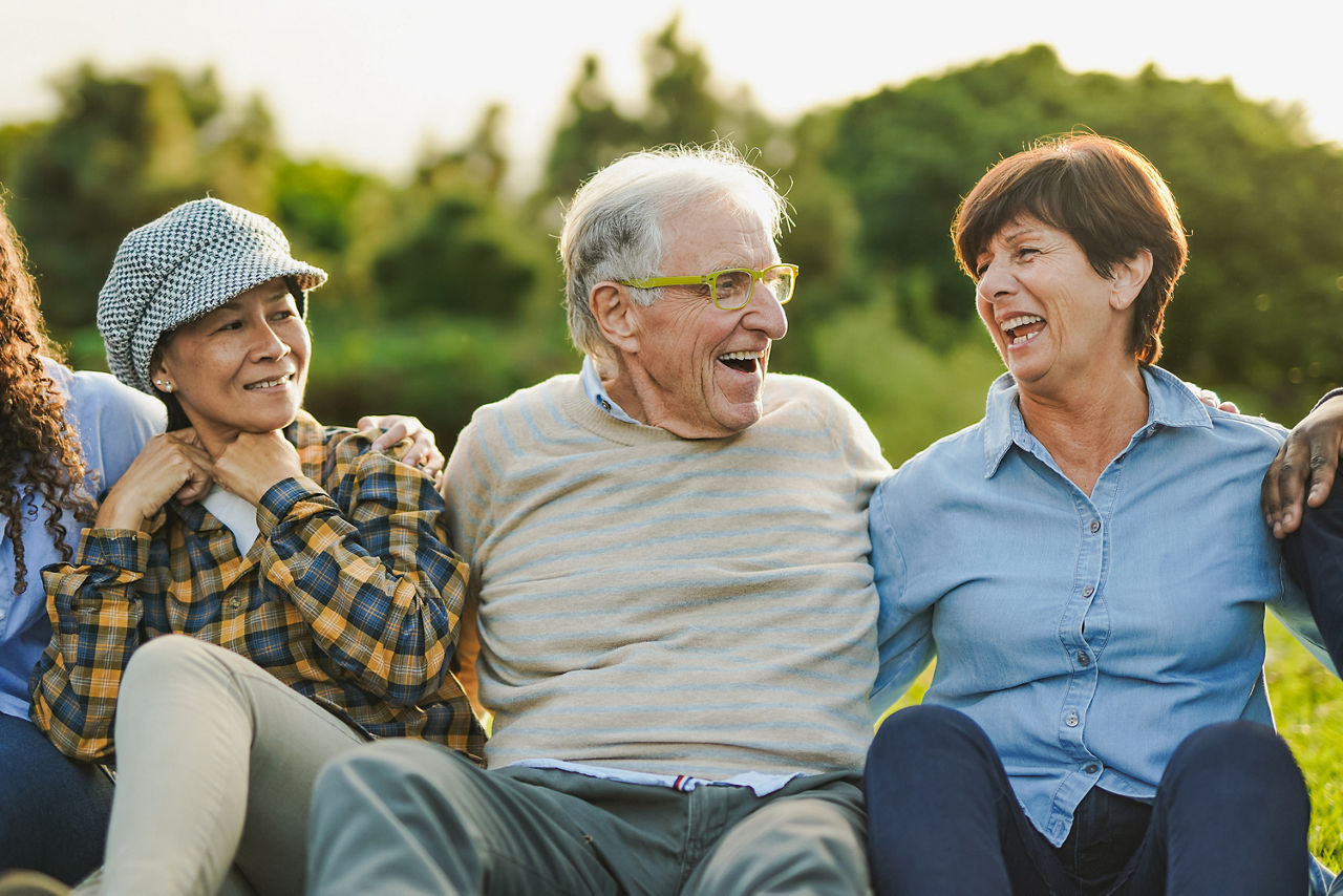 Ein Mann und zwei Frauen sitzen nebeneinander und Lachen
