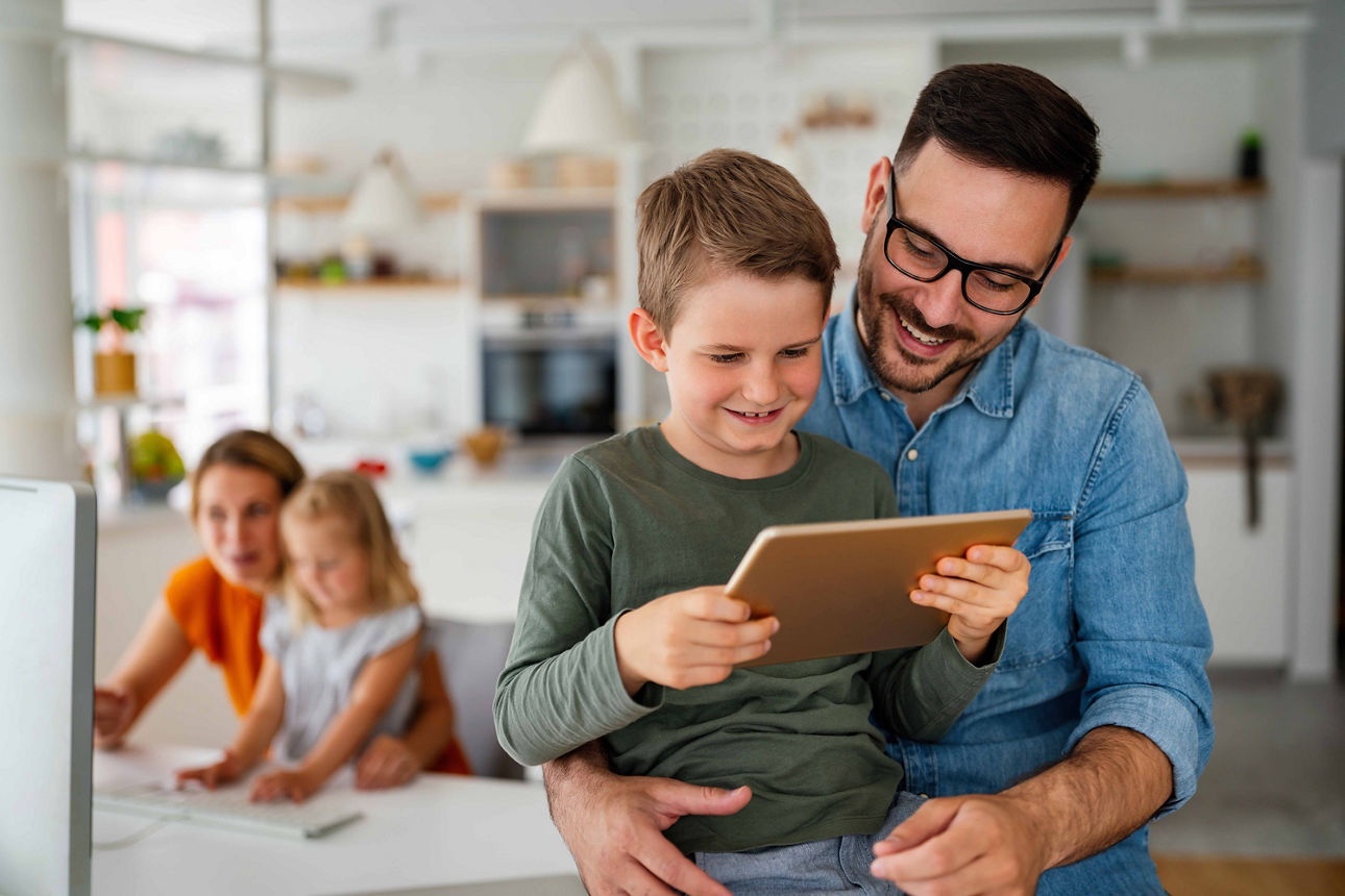 Vater schaut mit Sohn in Notebook