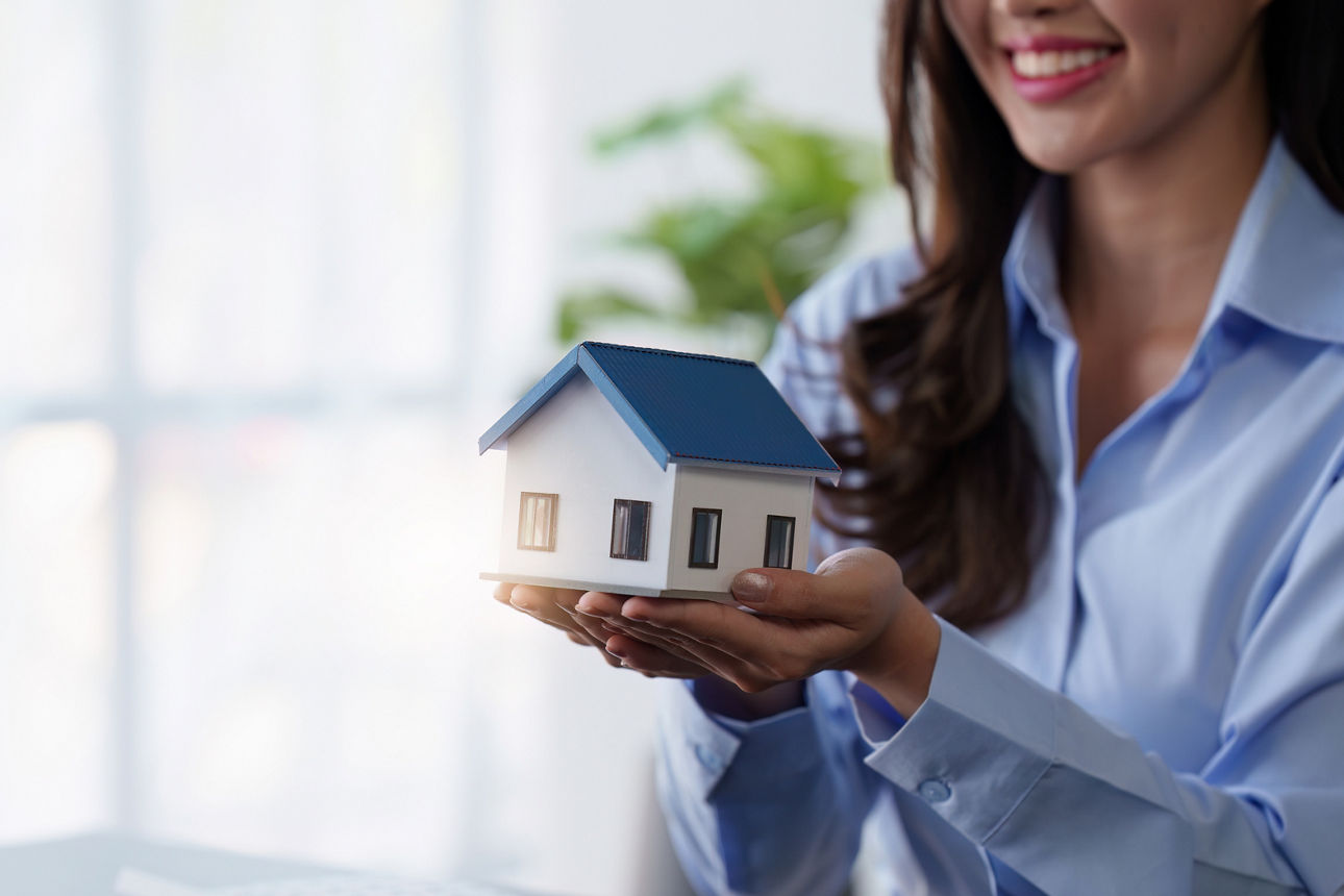 Eine Geschäftsfrau schaut sich ein Modellhaus an