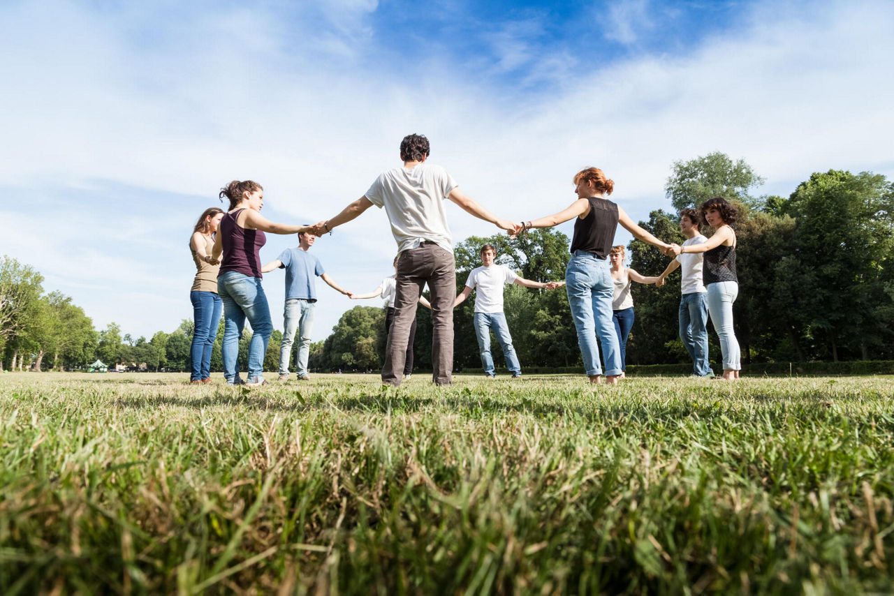 Gruppe mit Personen Hände haltend im Park