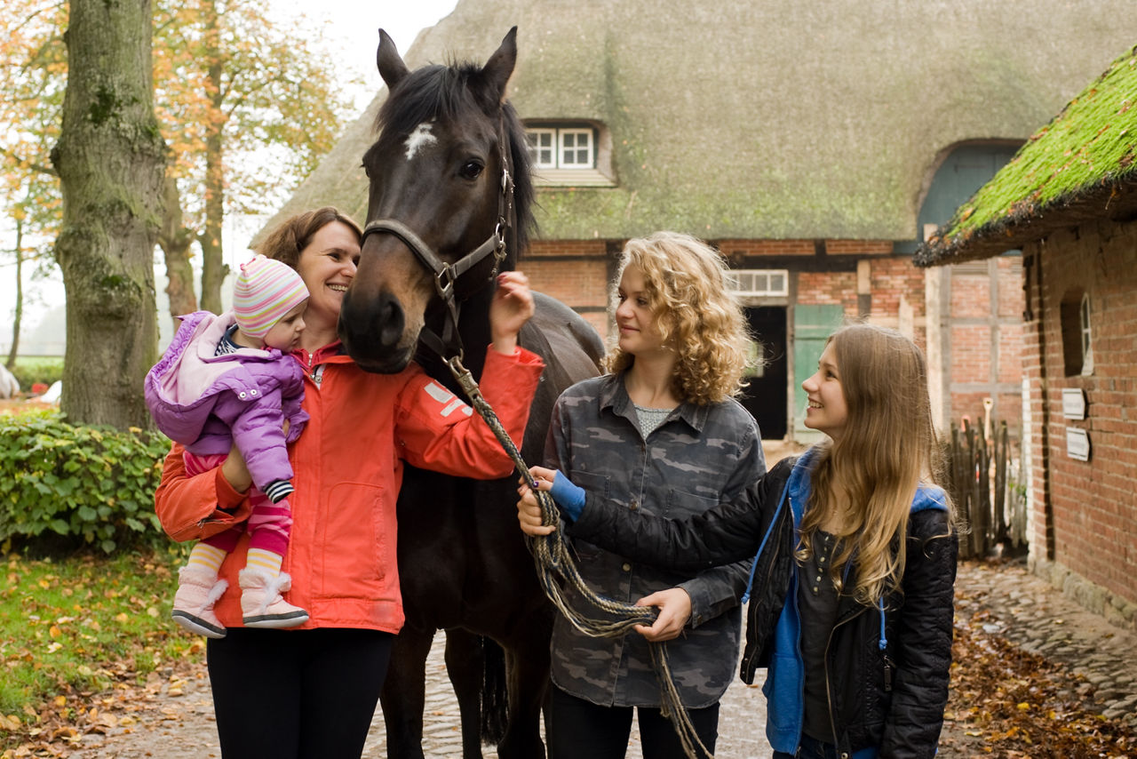 Familie auf dem Bauernhof mit Pferd