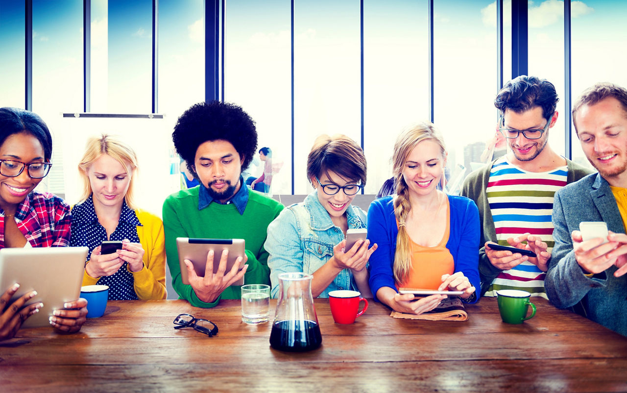 Gruppe von jungen Menschen die auf ihr Smartphone sehen