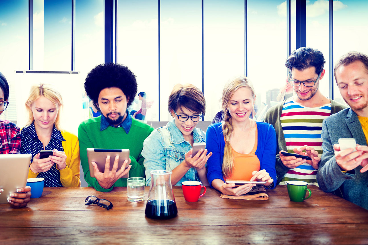 Gruppe von jungen Menschen die auf ihr Smartphone sehen