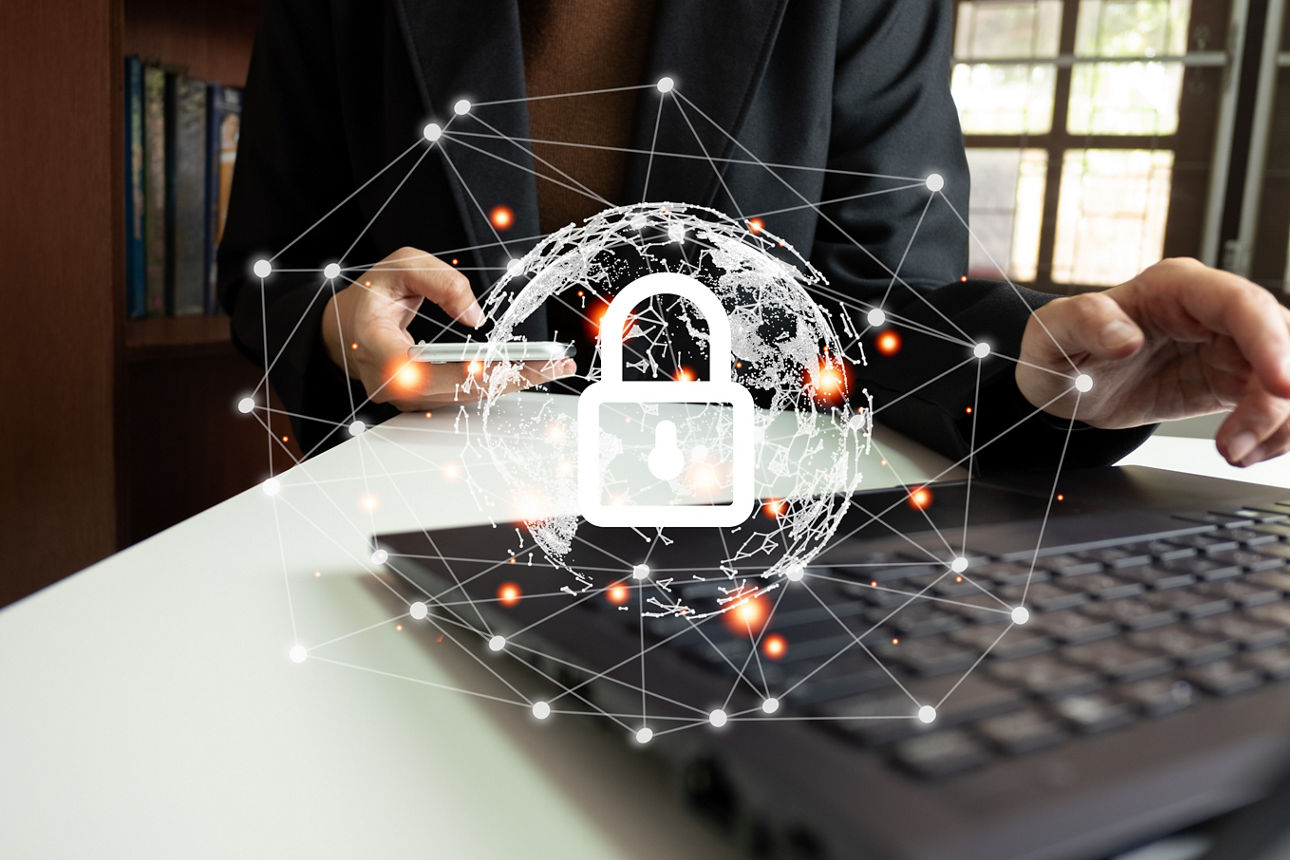Ein Mensch sitzt vor dem Laptop und Schloss symbolisiert Sicherheit