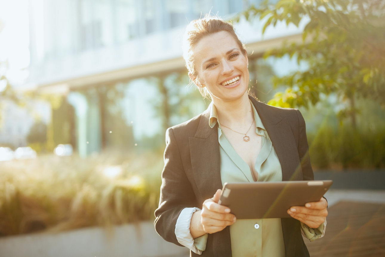 Frau mit Tablet im Grünen