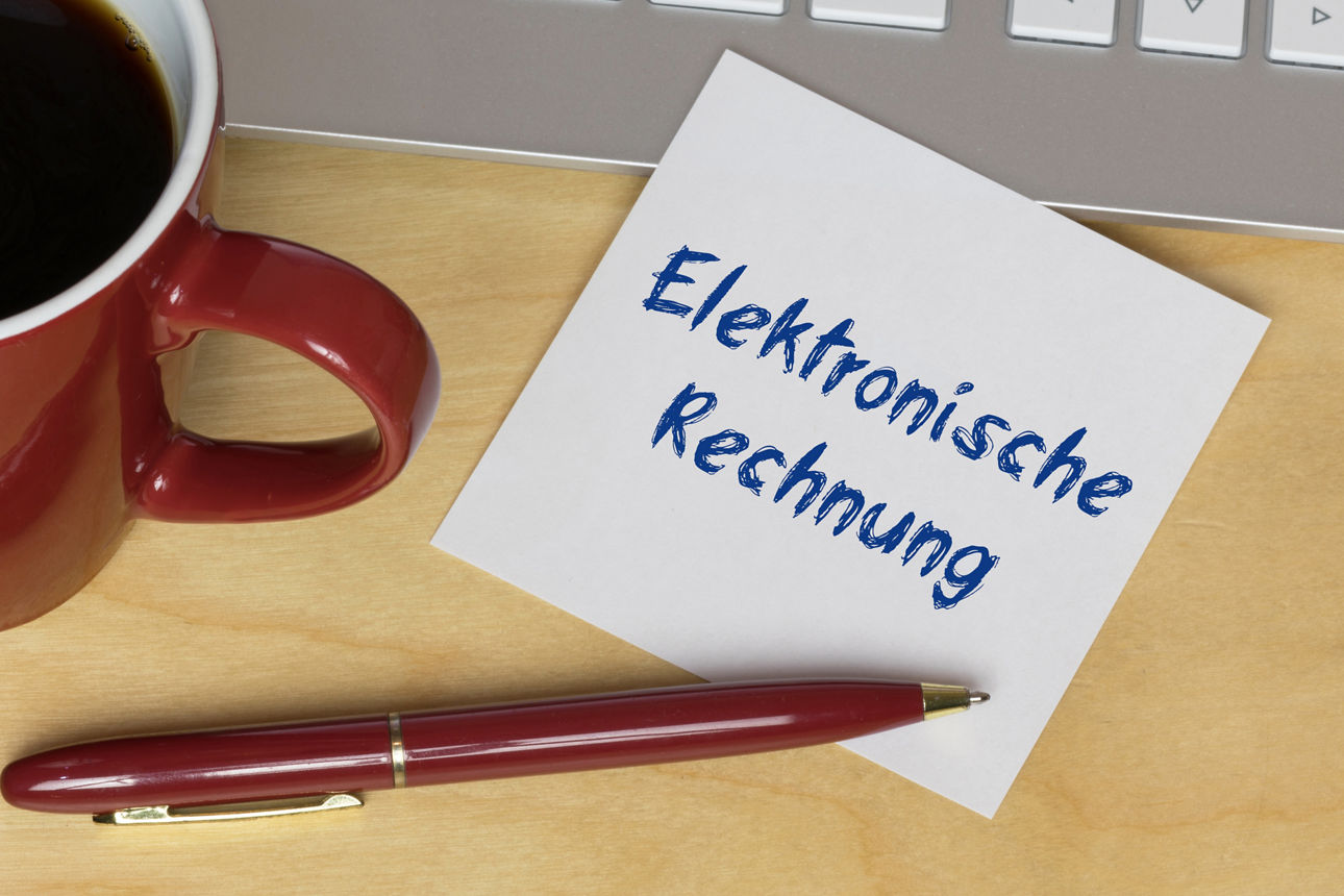 Ein Zettel liegt auf einer Tastatur. Auf dem Zettel steht "Elektronische Rechnung"