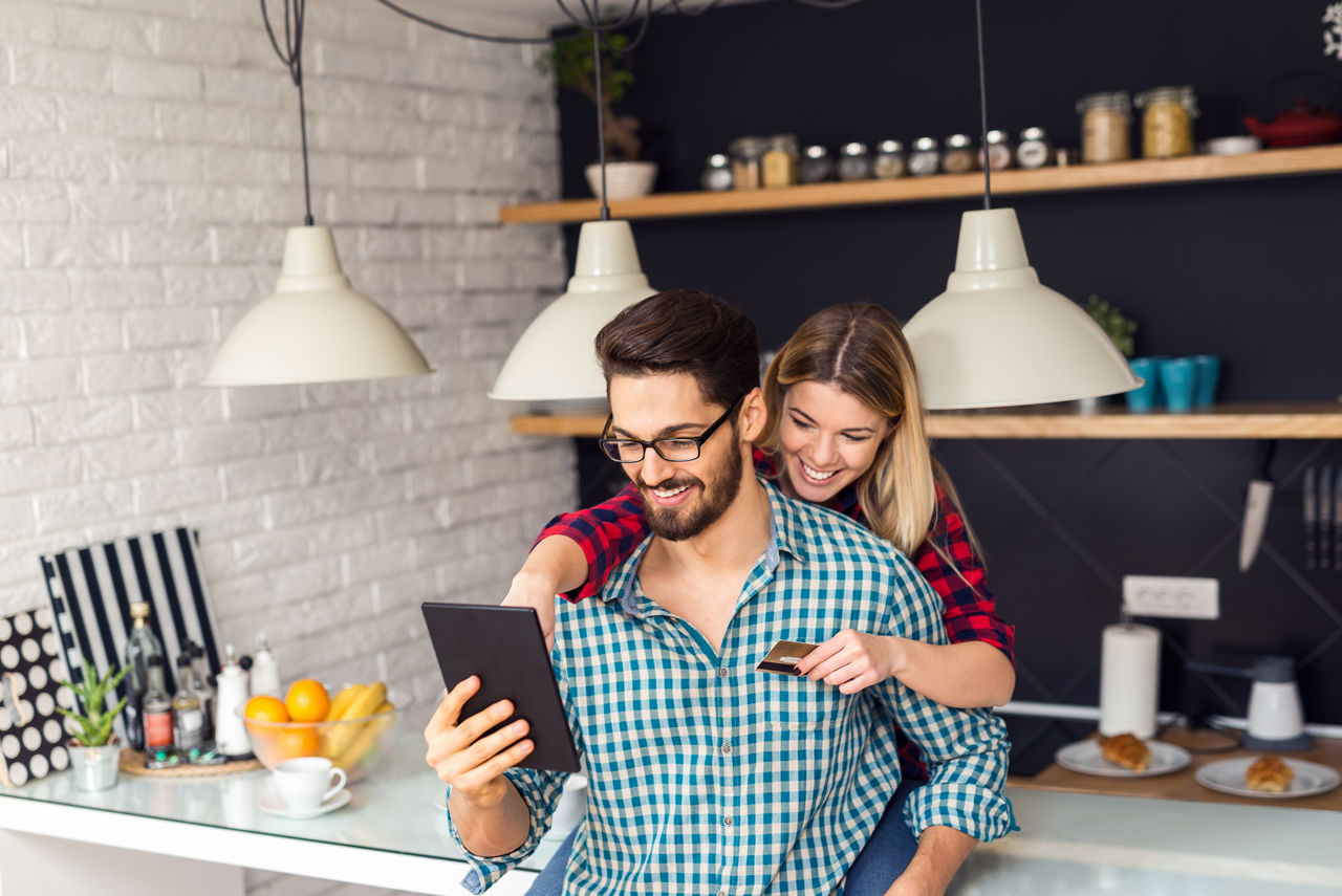 Shot of a women holding a credit card and purchasing online.