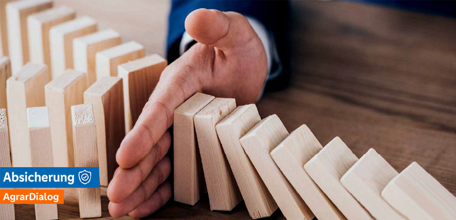 Hand stoppt kippende Domino-Reihe