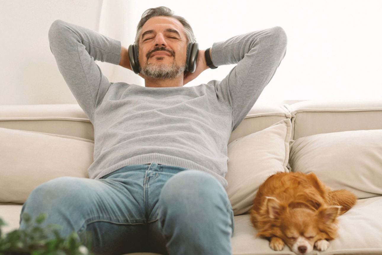 Mann liegt entspannt auf der Couch