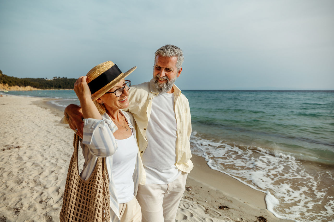 Ein älteres Ehepaar geht am Strand spazieren