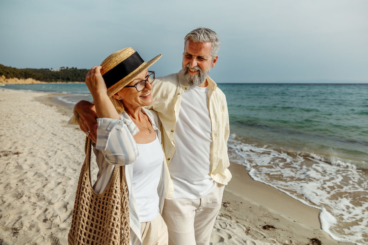Ein älteres Ehepaar geht am Strand spazieren
