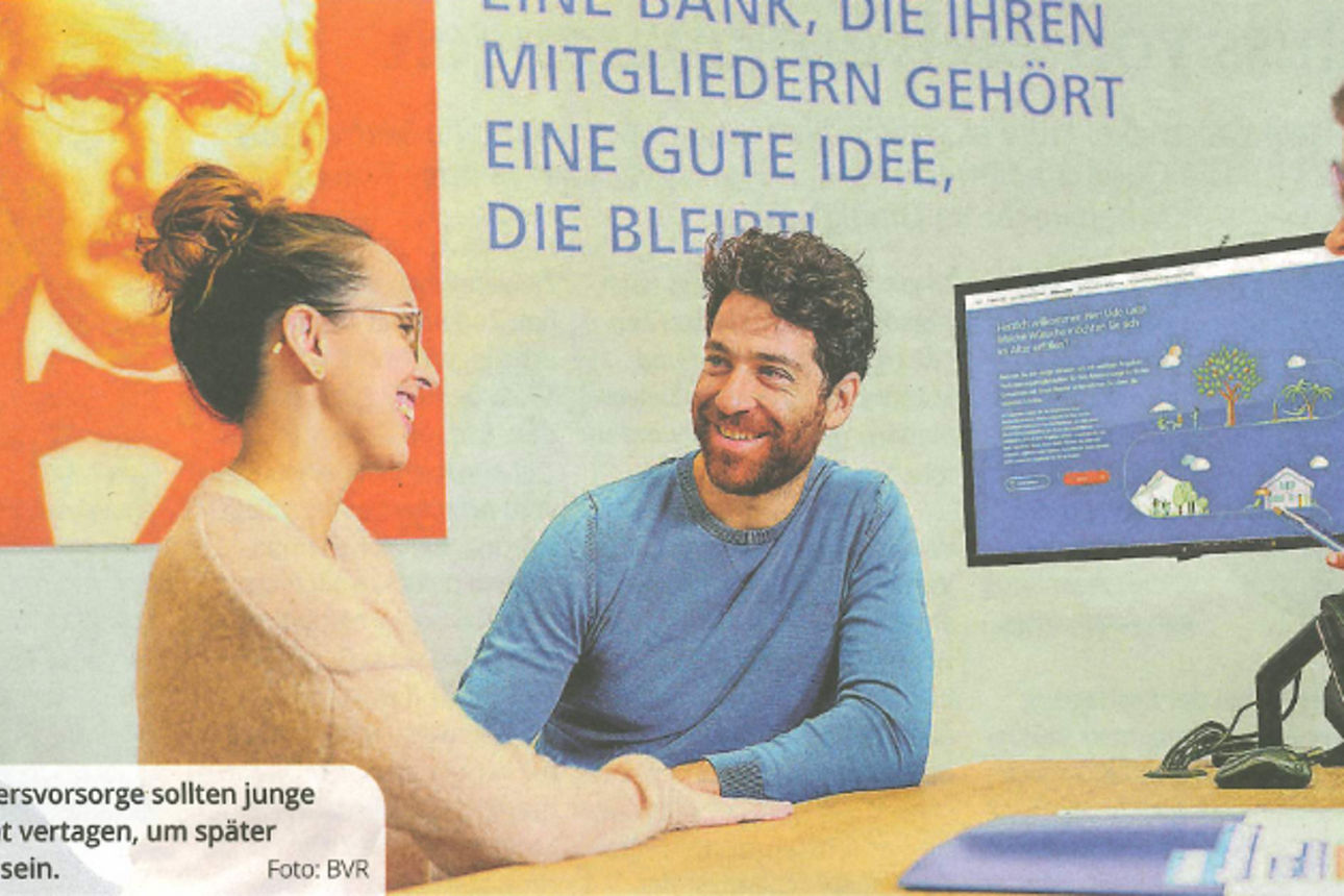 Eine Frau in einem blauen Blazer erklärt einem jungen Paar etwas.
