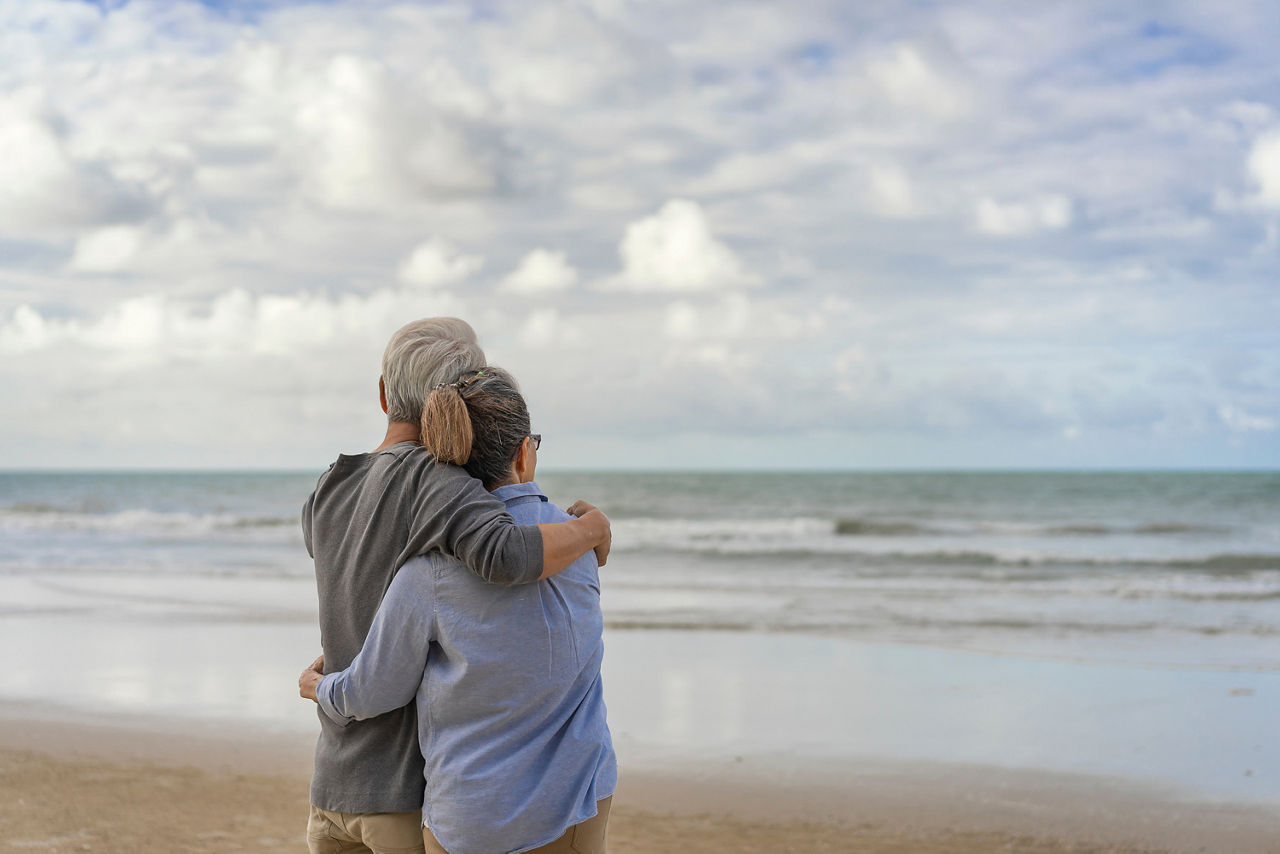 Älteres Paar umarmt sich und entspannt am Meer – Urlaubsstimmung und Nähe.