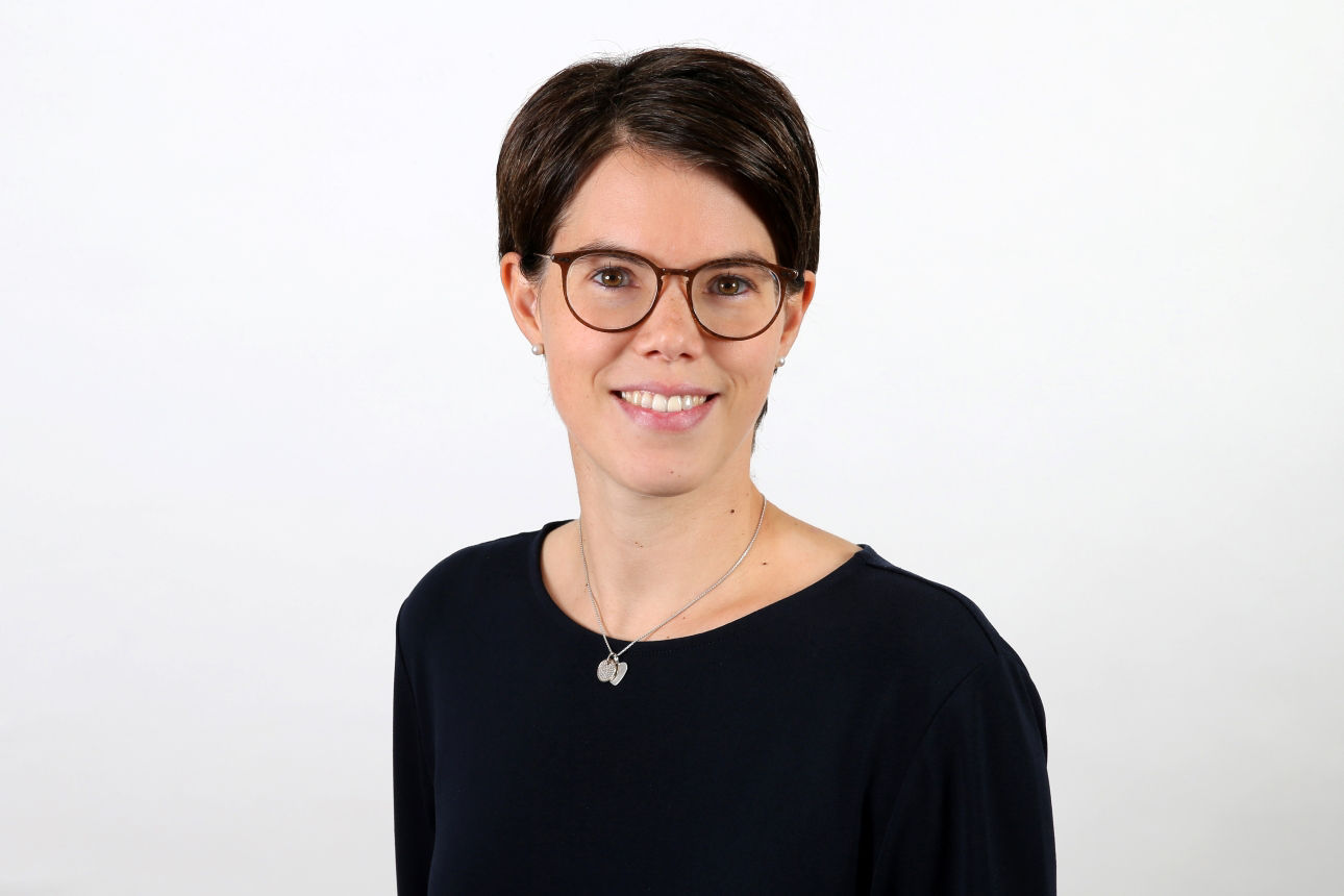 Eine lächelnde Frau schaut in die Kamera.