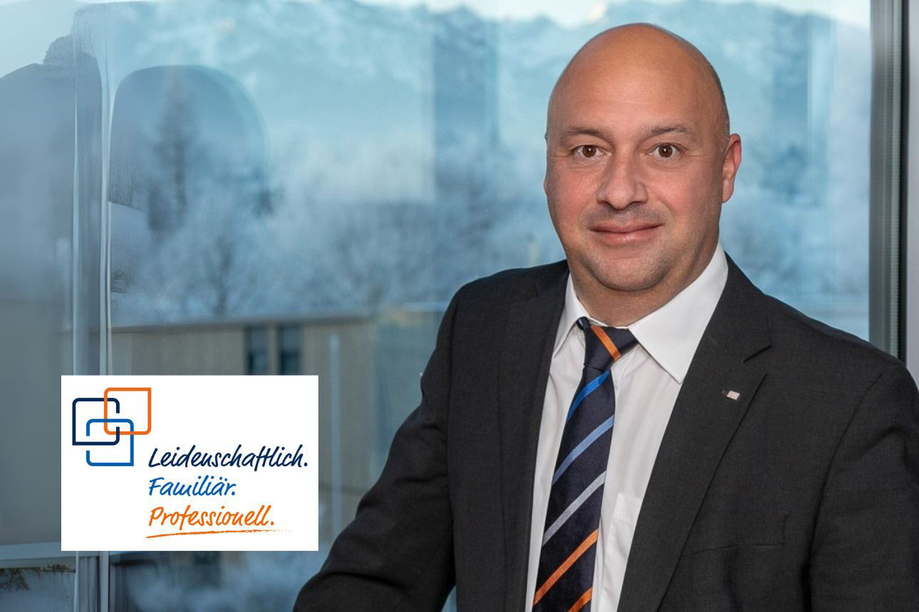 Porträt von Andreas Schmidpeter, einem lächelnden Mann mit Glatze im Anzug mit Krawatte vor einem Fenster mit Winterlandschaft. Daneben das Firmenlogo und der Slogan "Leidenschaftlich. Familiär. Professionell."
