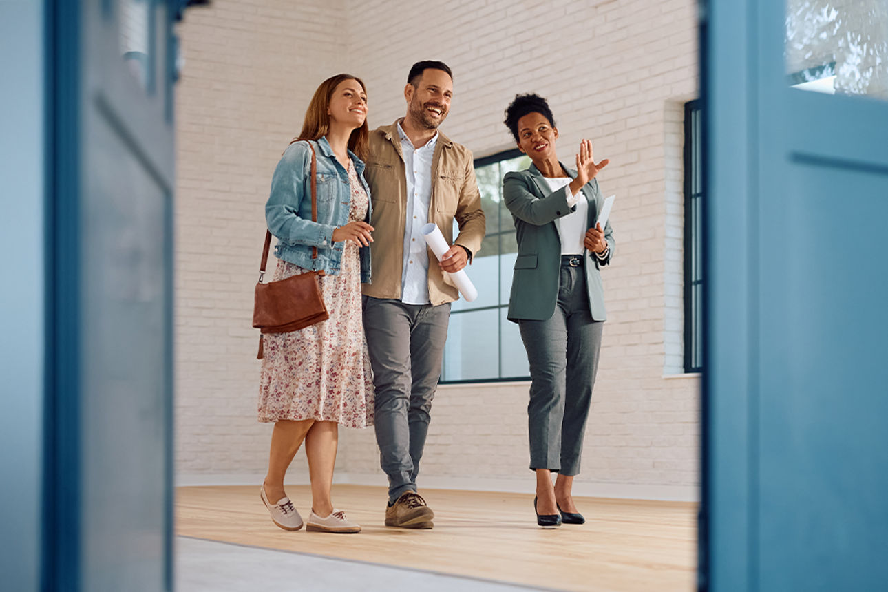 Junges Paar im Haus hinter offener Tür im Gespräch mit Beraterin