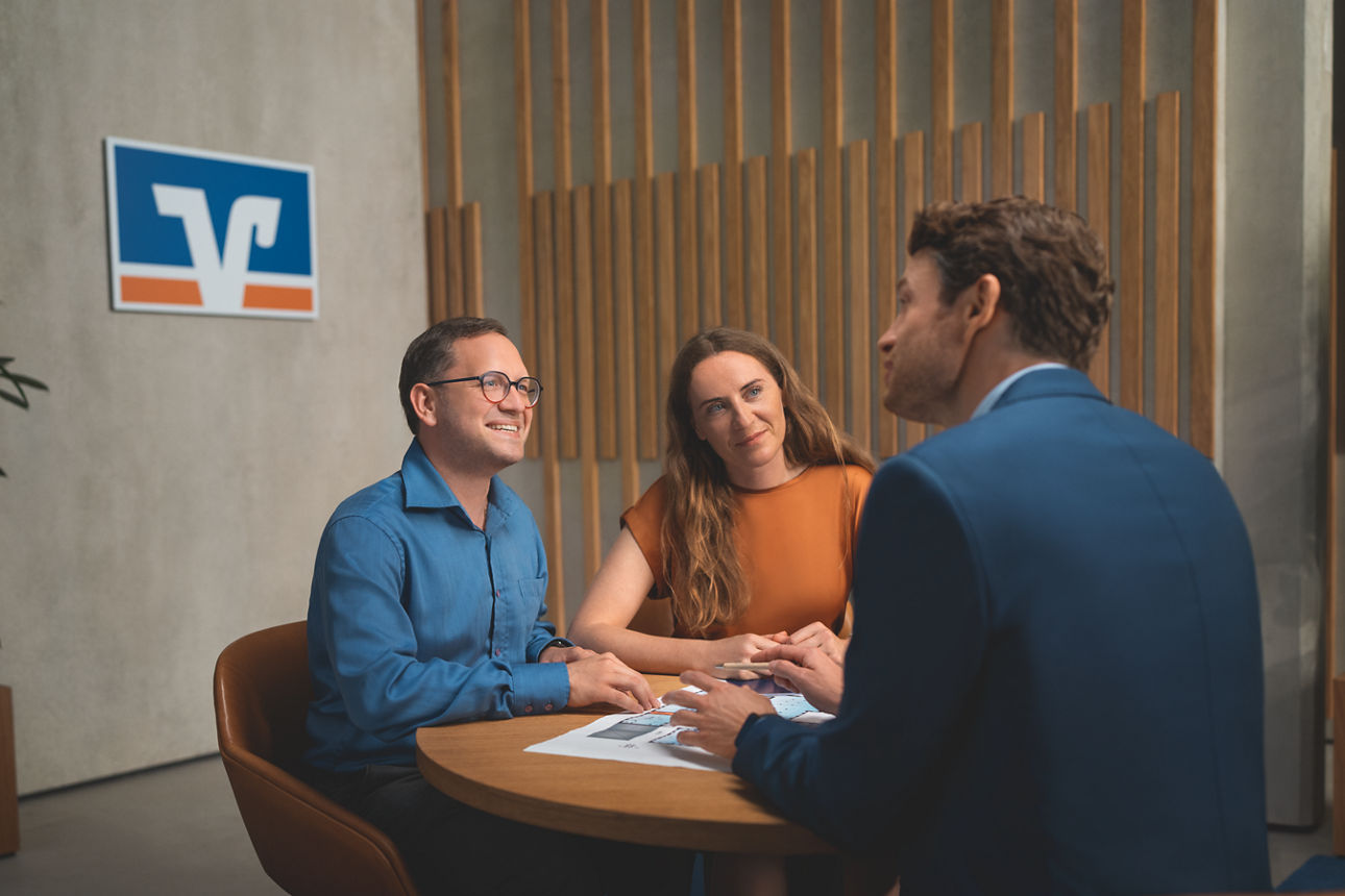 Berater sitzt mit Ehepaar am Tisch