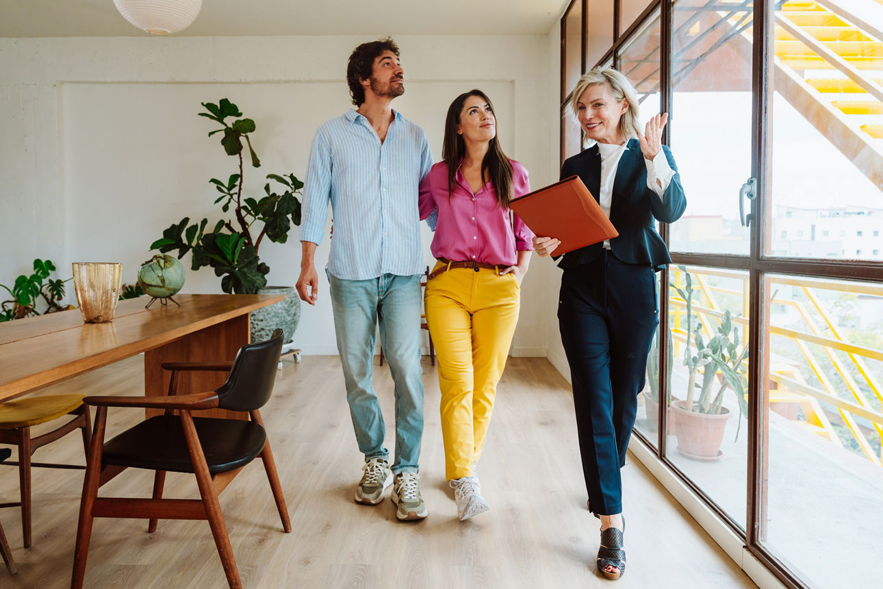 Maklerin zeigt jungem Pärchen eine Wohnung 
