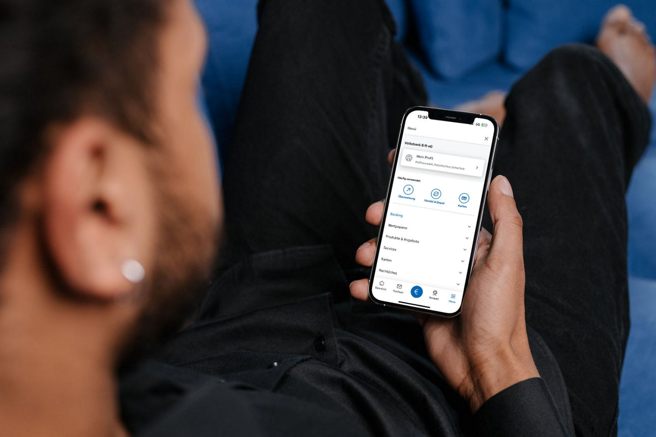Junger Mann mit Smartphone, auf dem die VR Banking App geöffnet ist