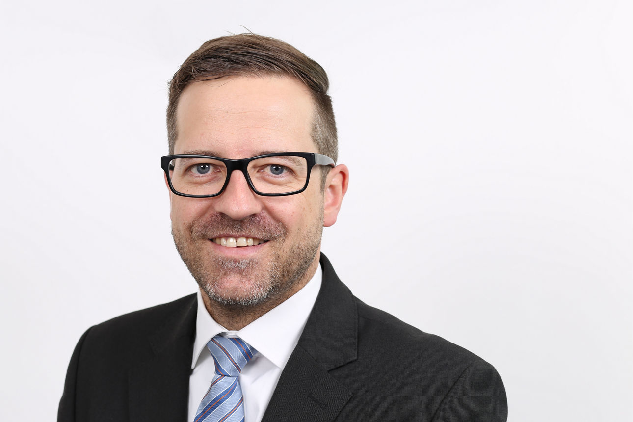 Mitarbeiter, Thomas Appel, vor weißem Hintergrund lächelt in die Kamera