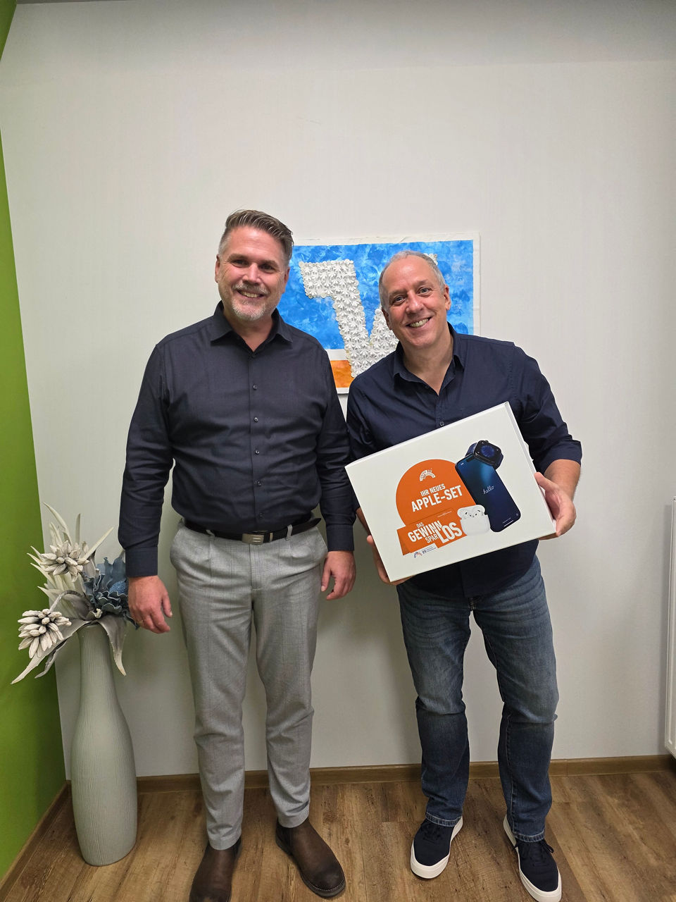 Kundenberater Marcel Sagasser übergibt ein Apple-Set an seinen Kunden