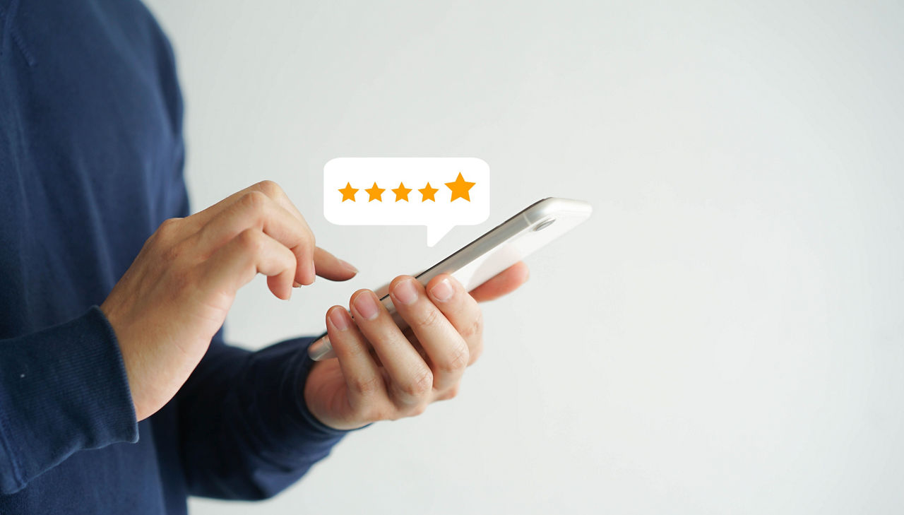 Jemand hält ein Smartphone in der Hand und schaut auf eine App 